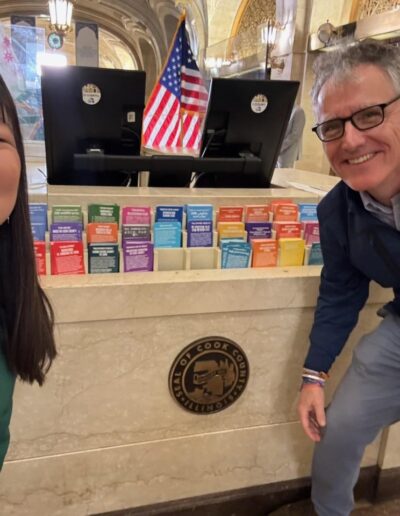 Sheriff Dart poses for a selfie with a woman in front of a marble desk.