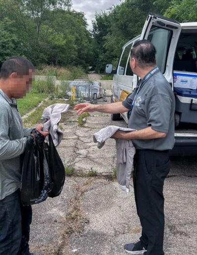 SHARP RESEARCH COORDINATOR SERGIO CISNEROS GIVES CLOTHES TO INDIVIDUAL IN HOMELESS ENCAMPMENT ON 31ST CICERO