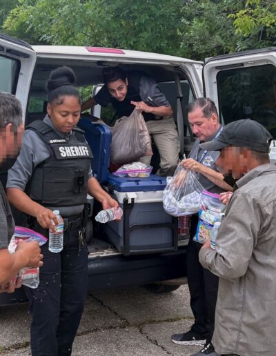 OFFICER SHAVONIA BROWN HANDS OUT WATER TO INDIVIDUALS AT HOMELESS ENCAMPMENT ON 31ST CICERO